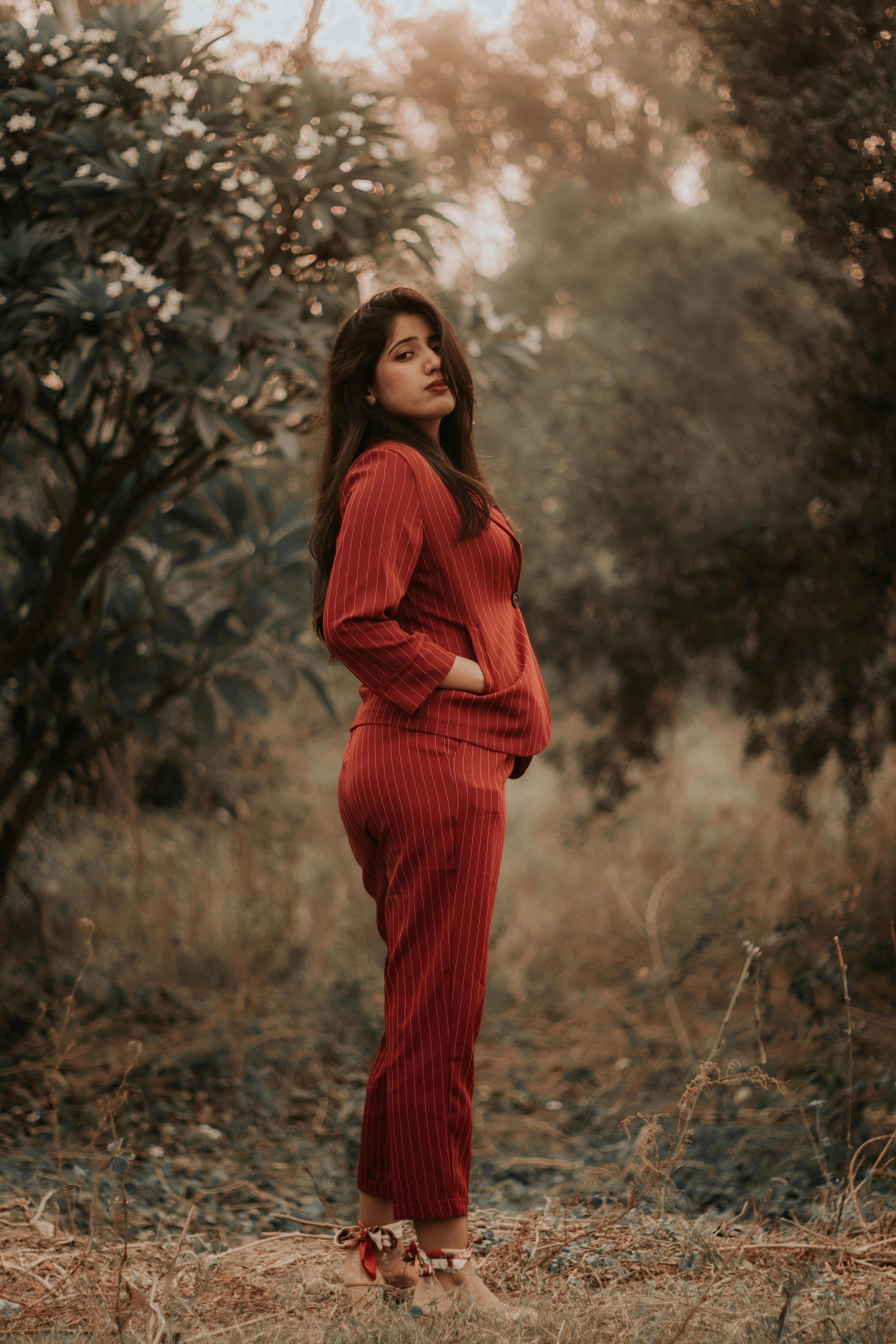 woman in red long sleeve dress standing on brown grass field